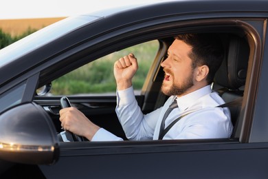 Photo of Man singing in car, view from outside