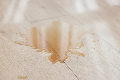 Photo of Puddle of spilled drink on wooden floor, closeup