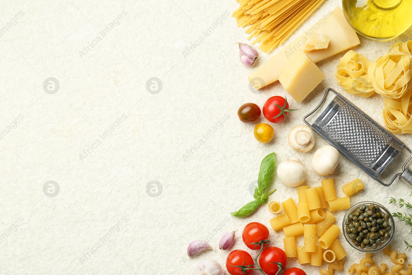 Photo of Different types of pasta, grater, spices and products on light table, flat lay. Space for text