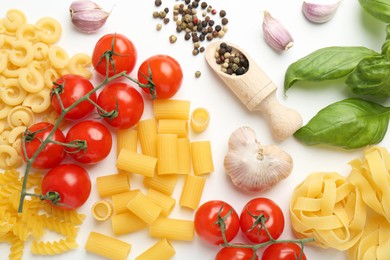 Photo of Different types of pasta, spices and products on white background, top view