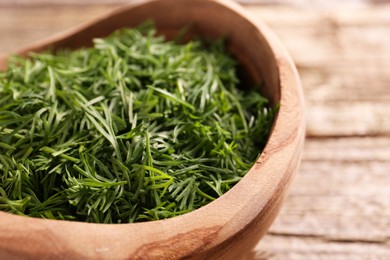 Photo of Fresh cut dill in bowl on table, closeup