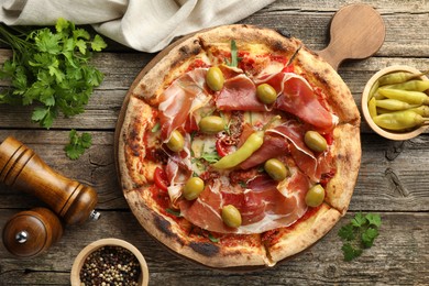 Tasty pizza and ingredients on wooden table, top view