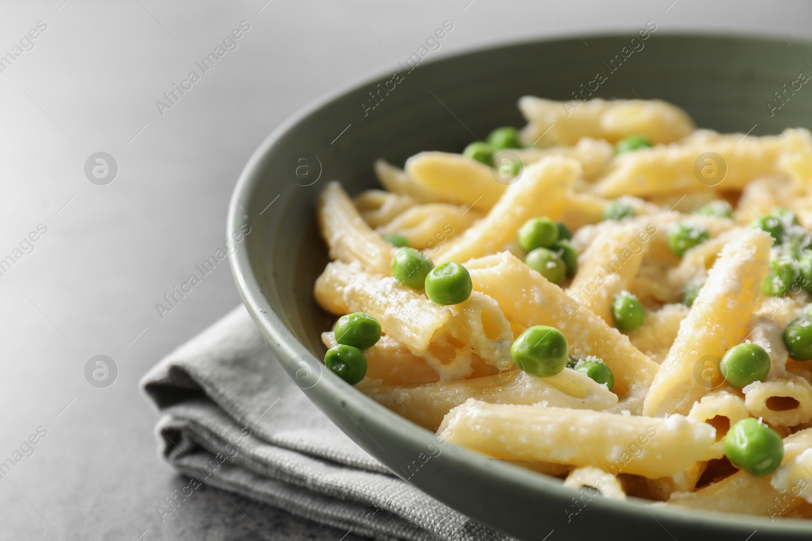 Photo of Delicious pasta with green peas and cheese on grey table, closeup