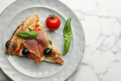 Tasty pizza with cured ham, olives, tomato and basil on white marble table, top view. Space for text