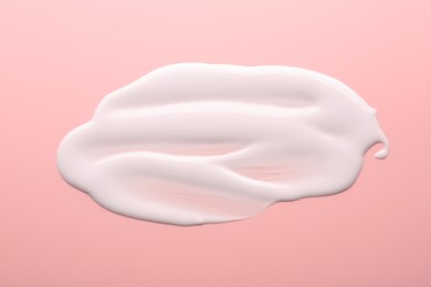 Photo of Sample of face cream on pink background, top view