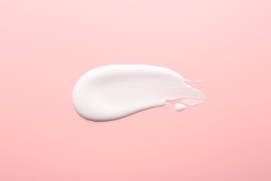 Photo of Sample of face cream on pink background, top view