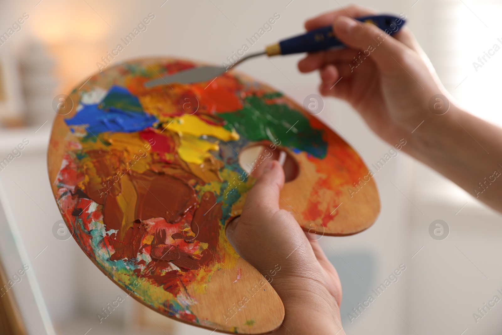 Photo of Woman with knife using palette indoors, closeup