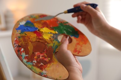 Photo of Woman with knife using palette indoors, closeup