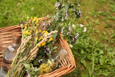 Tincture and flowers in wicker basket outdoors, closeup. Space for text