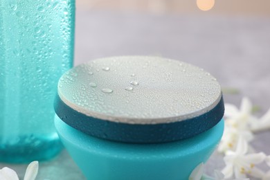 Cosmetic products in wet containers on table, closeup