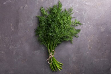 Bunch of fresh dill on grey textured table, top view