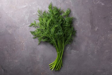 Photo of Bunch of fresh dill on grey textured table, top view