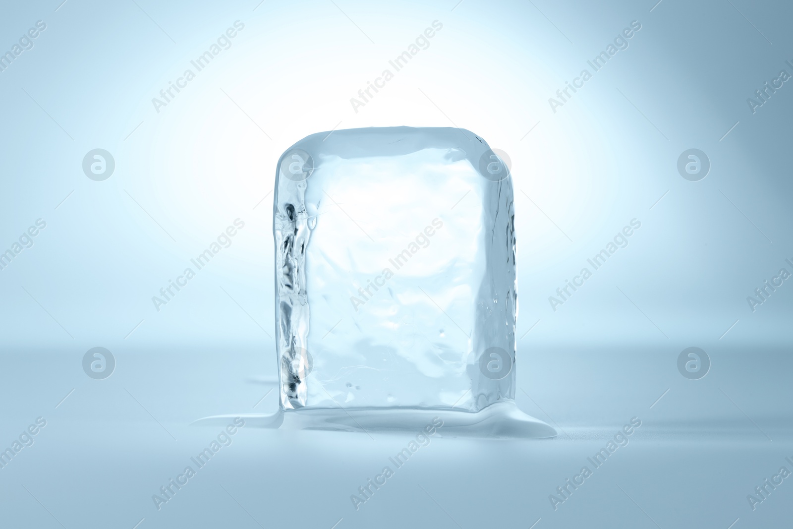 Photo of Cube of clear ice on light blue background