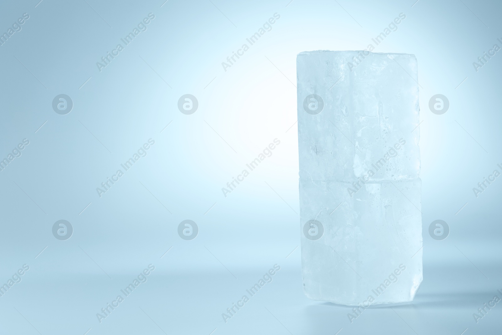 Photo of Blocks of clear ice on light blue background, space for text