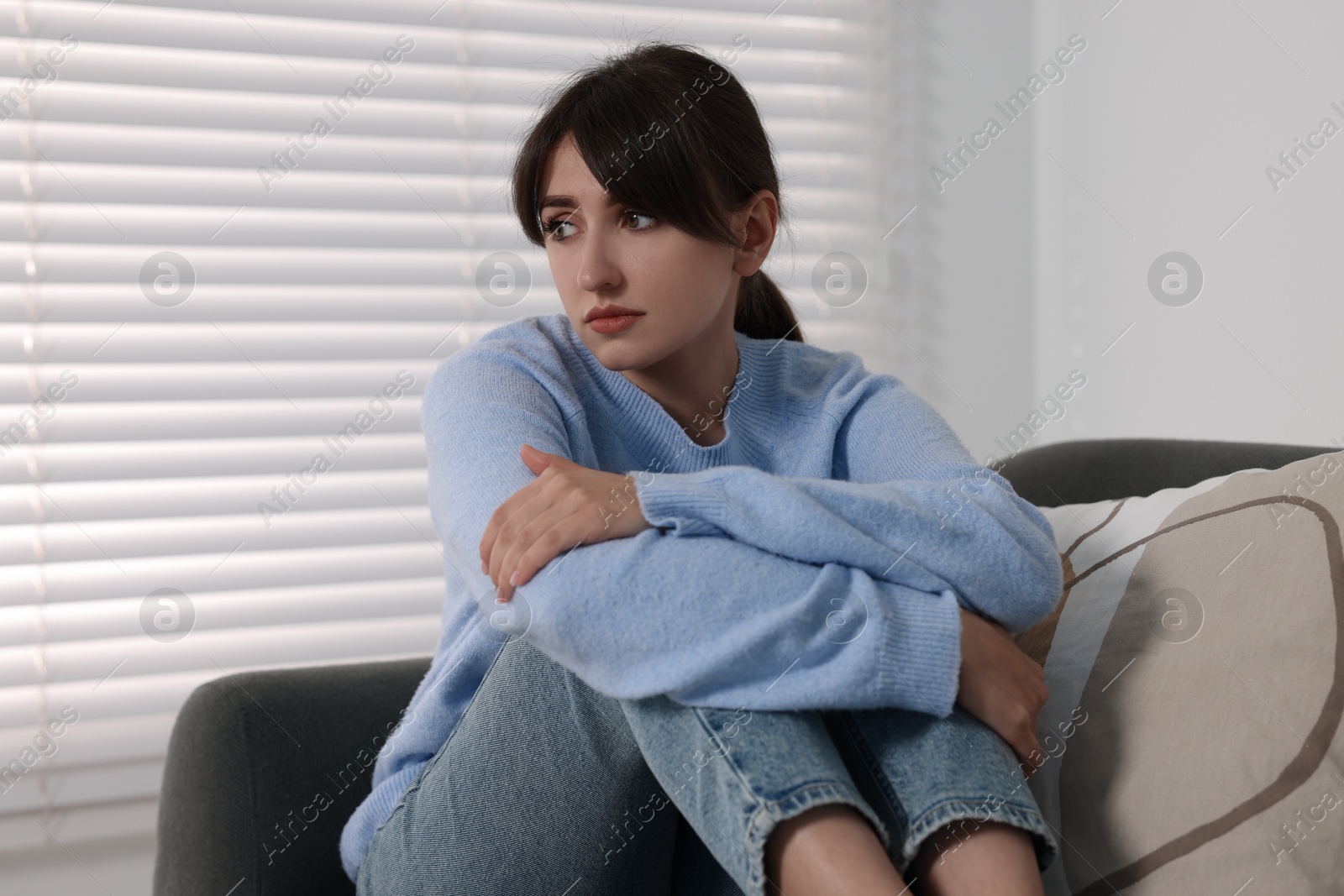 Photo of Loneliness concept. Sad woman sitting on sofa at home