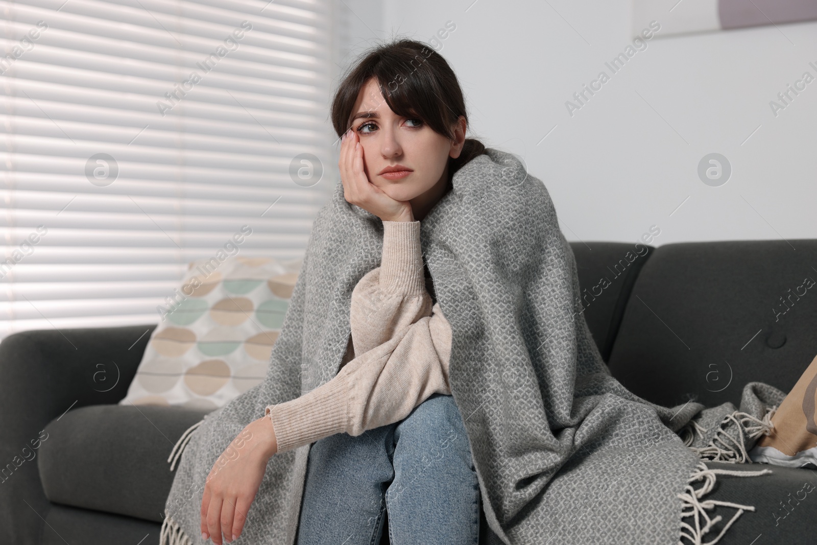 Photo of Loneliness concept. Sad woman sitting on sofa at home