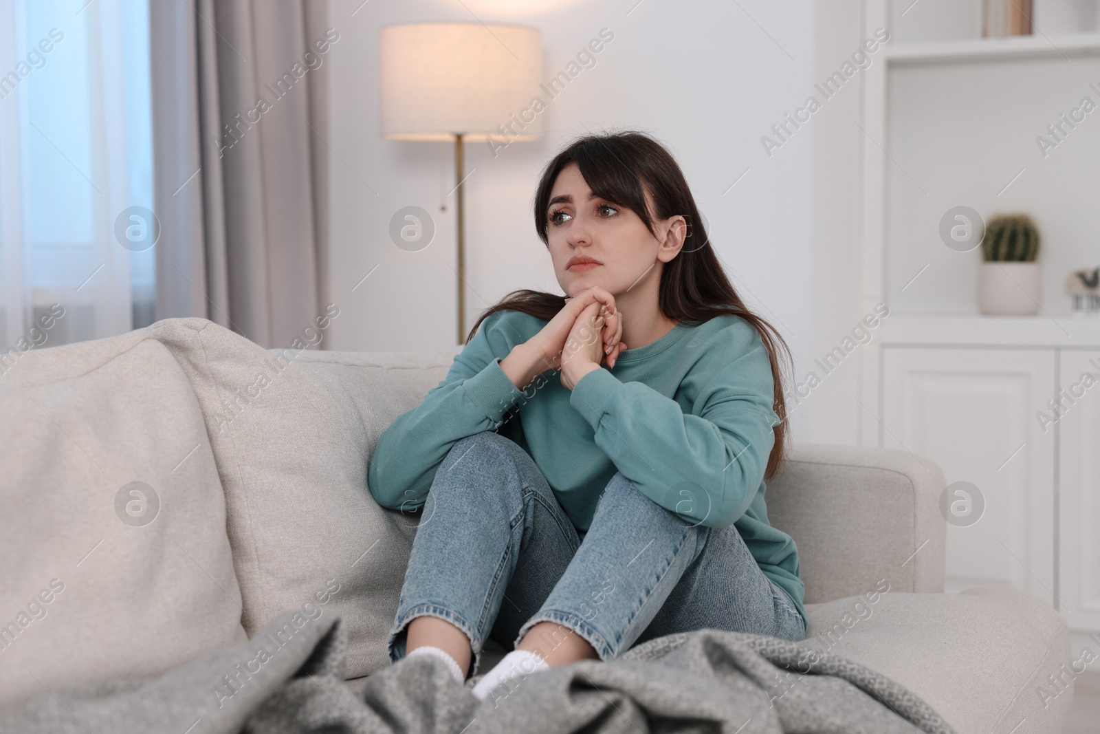 Photo of Loneliness concept. Sad woman sitting on sofa at home