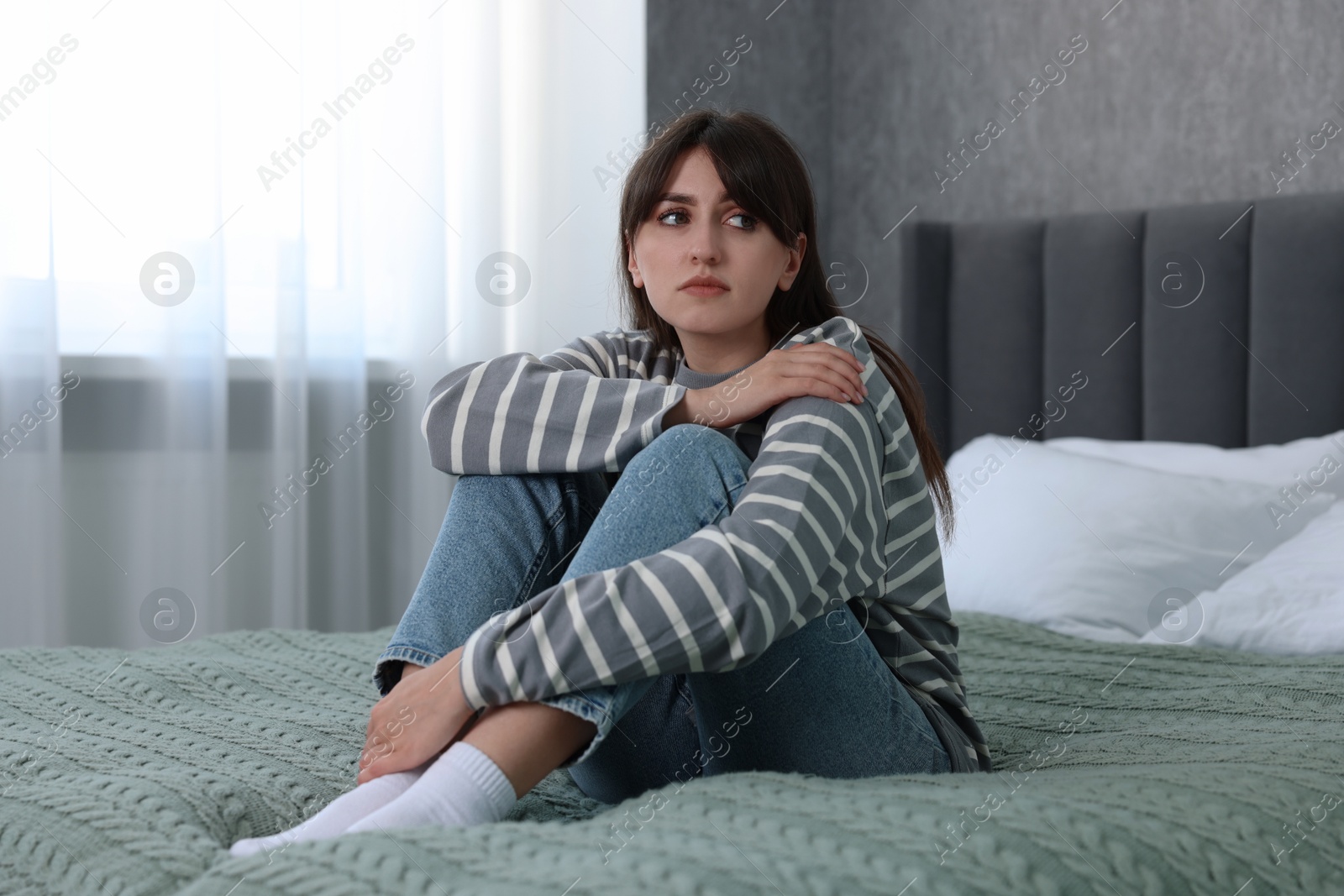 Photo of Loneliness concept. Sad woman sitting on bed at home