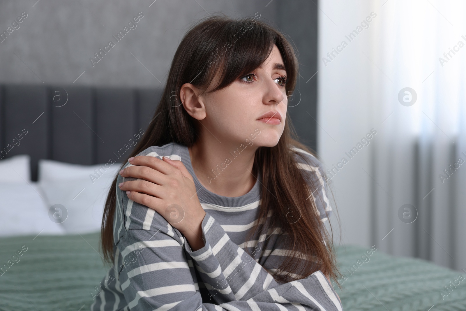 Photo of Loneliness concept. Sad woman sitting on bed at home