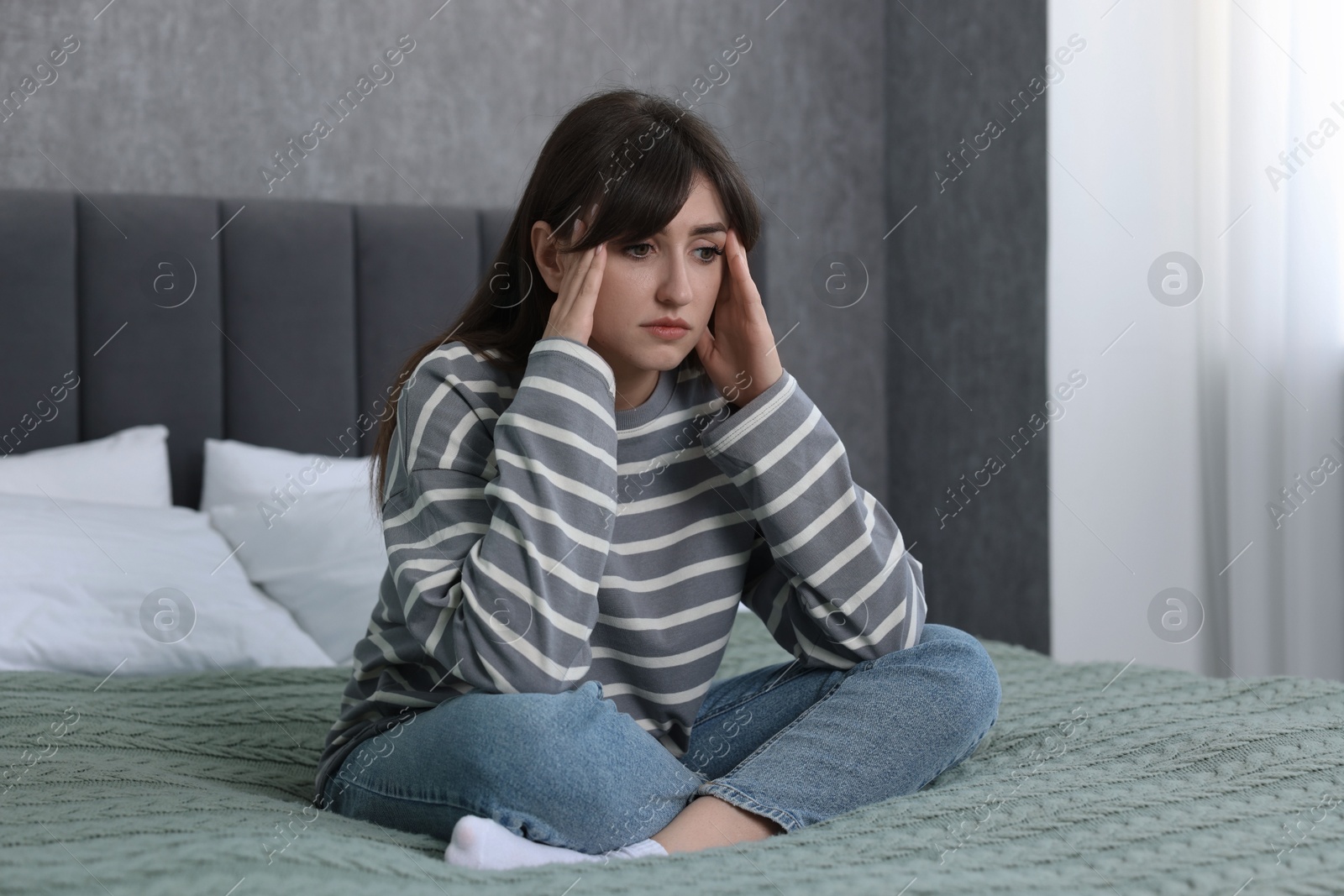 Photo of Loneliness concept. Sad woman sitting on bed at home