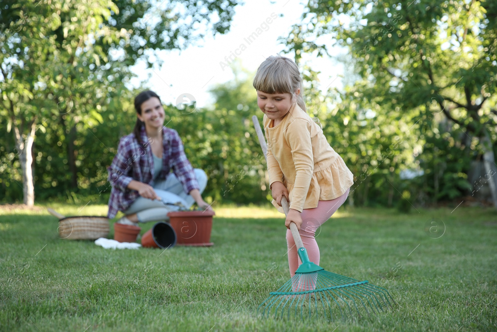 Photo of Mother and her daughter working together in garden