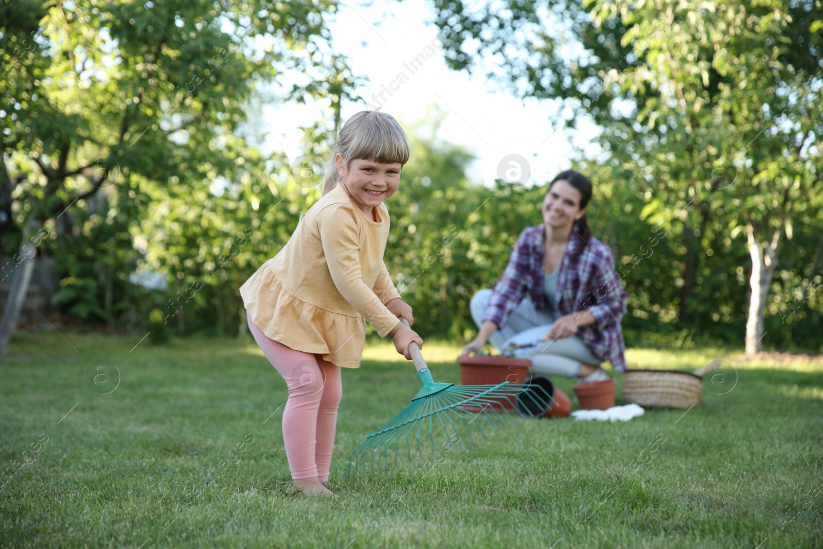 Photo of Mother and her daughter working together in garden