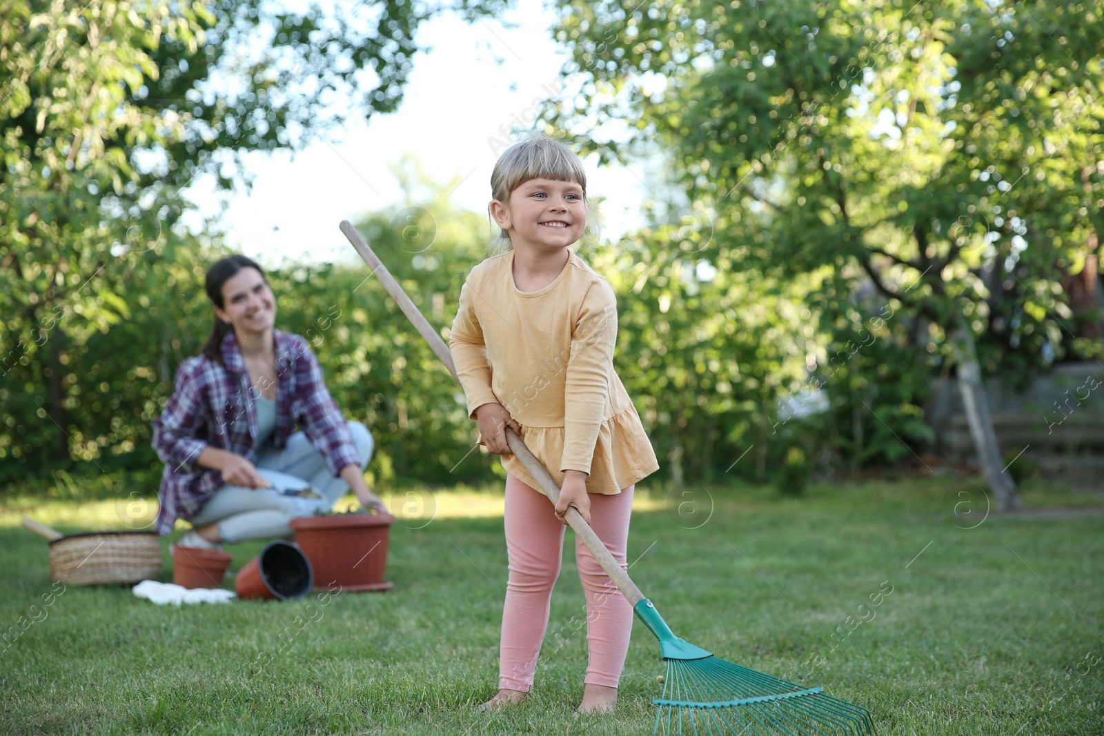 Photo of Mother and her daughter working together in garden