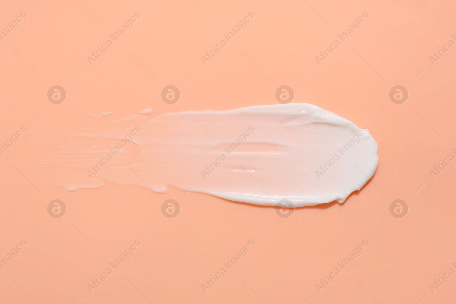 Photo of Sample of face cream on coral background, top view