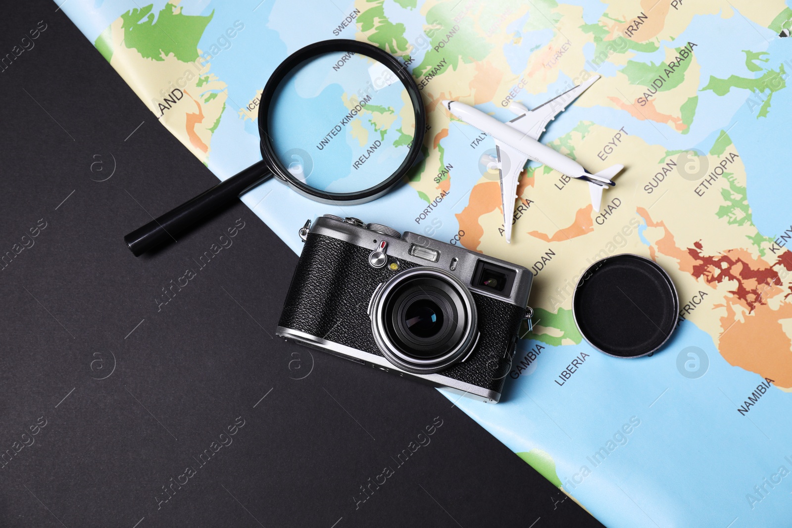 Photo of Travel blogger. Flat lay composition with vintage camera and map on black background