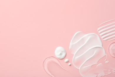 Samples of face cream on pink background, top view. Space for text