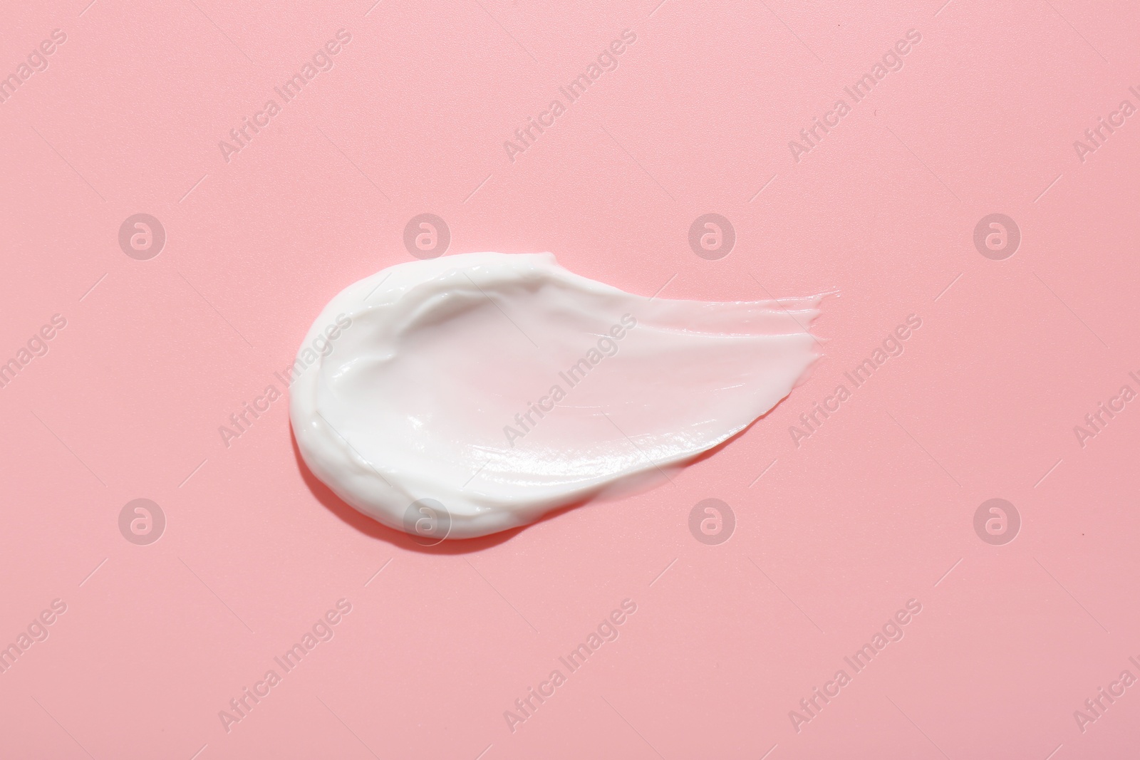 Photo of Sample of face cream on pink background, top view