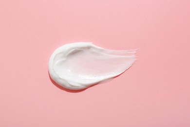 Sample of face cream on pink background, top view