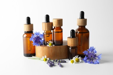 Photo of Aromatherapy. Different essential oils and flowers on white background