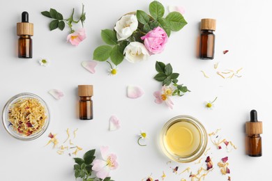 Photo of Aromatherapy. Essential oils, flowers and petals on white background, flat lay