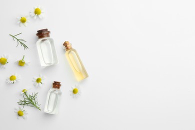 Photo of Aromatherapy. Essential oils and chamomiles on white background, flat lay. Space for text