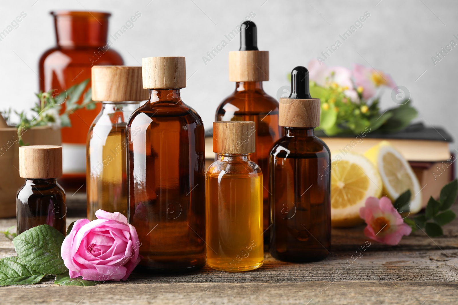 Photo of Aromatherapy. Different essential oils and flowers on wooden table