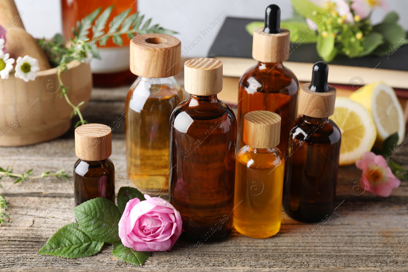 Photo of Aromatherapy. Different essential oils and flowers on wooden table