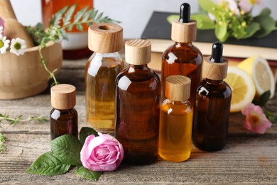 Photo of Aromatherapy. Different essential oils and flowers on wooden table