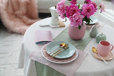 Photo of Beautiful table setting with pink peonies in dining room