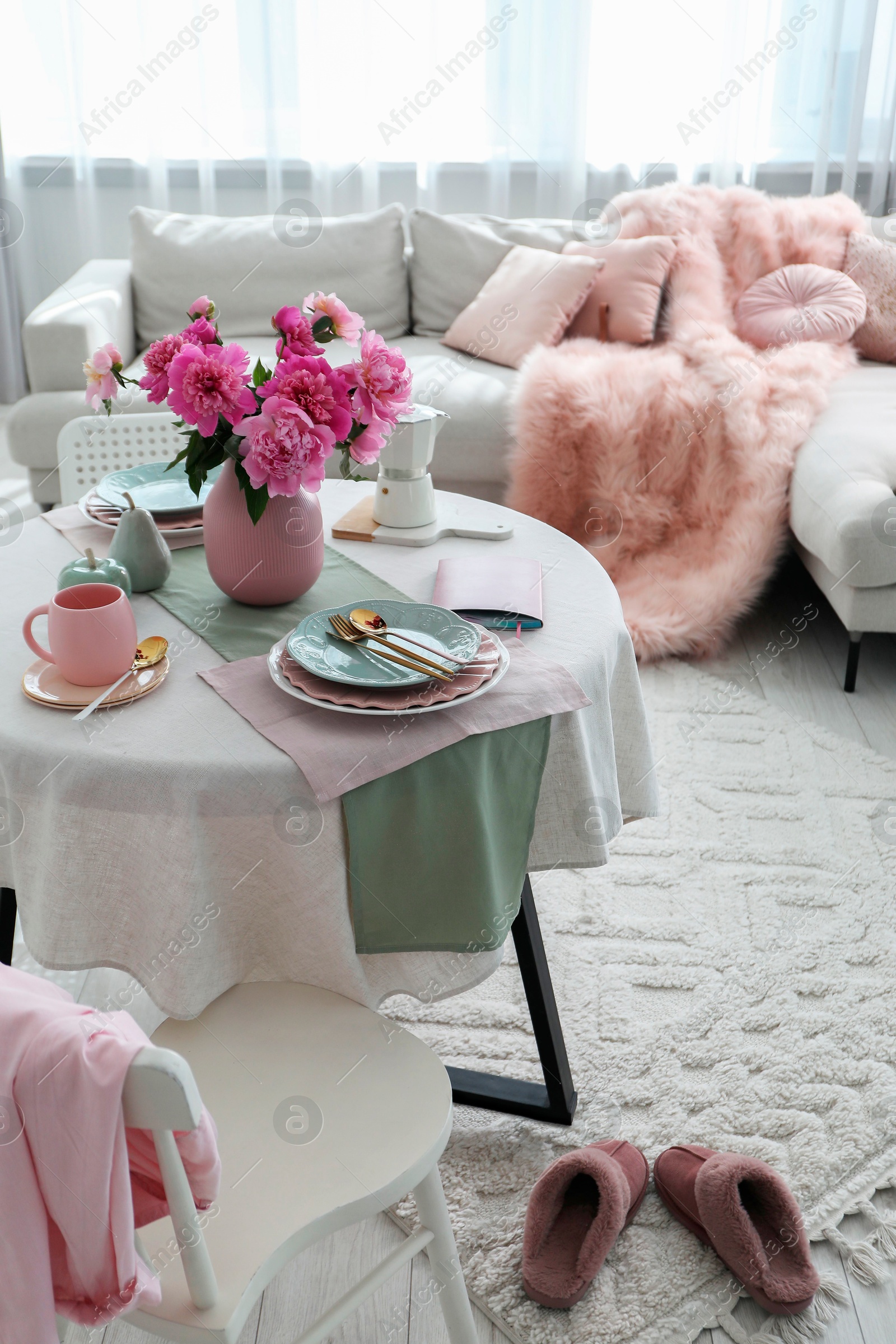 Photo of Beautiful table setting with pink peonies in living room