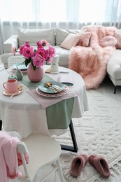 Beautiful table setting with pink peonies in living room