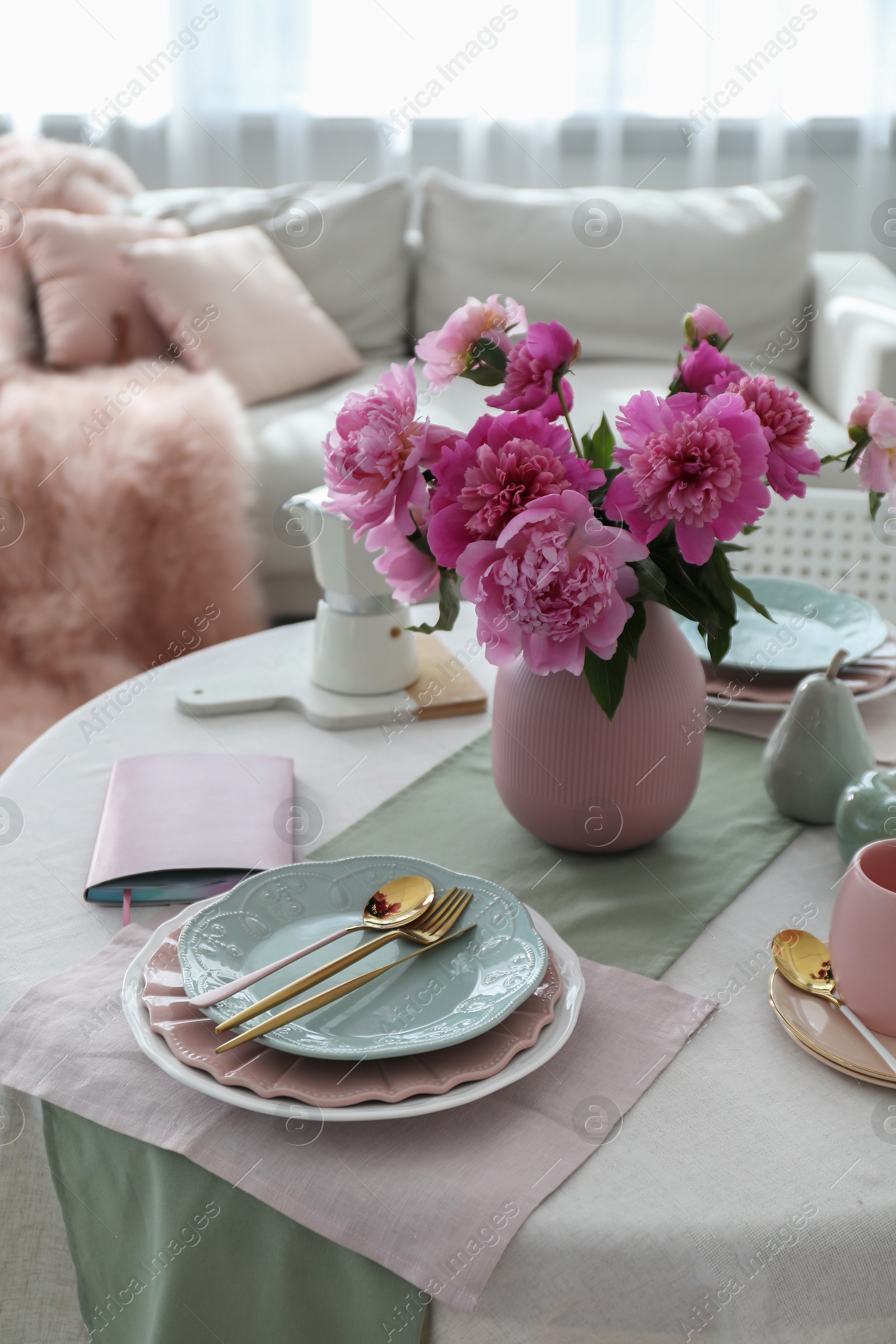 Photo of Beautiful table setting with pink peonies in living room