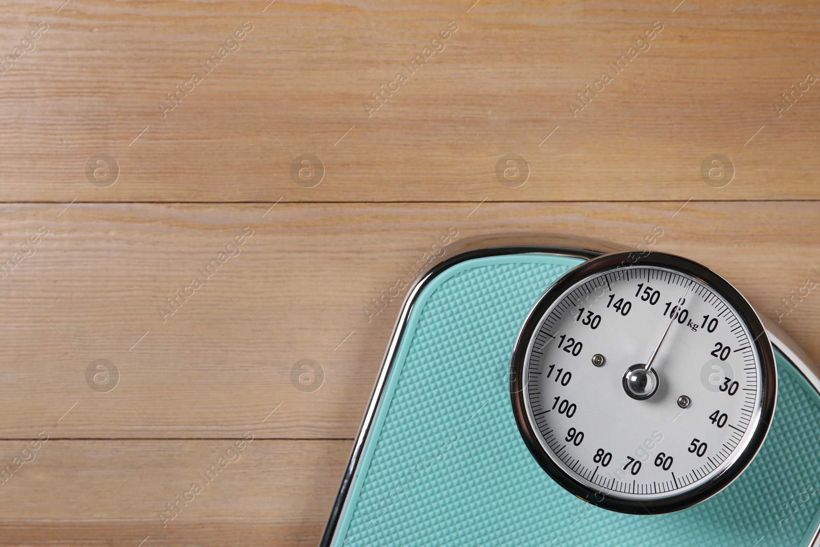 Photo of One scale on wooden floor, top view. Space for text