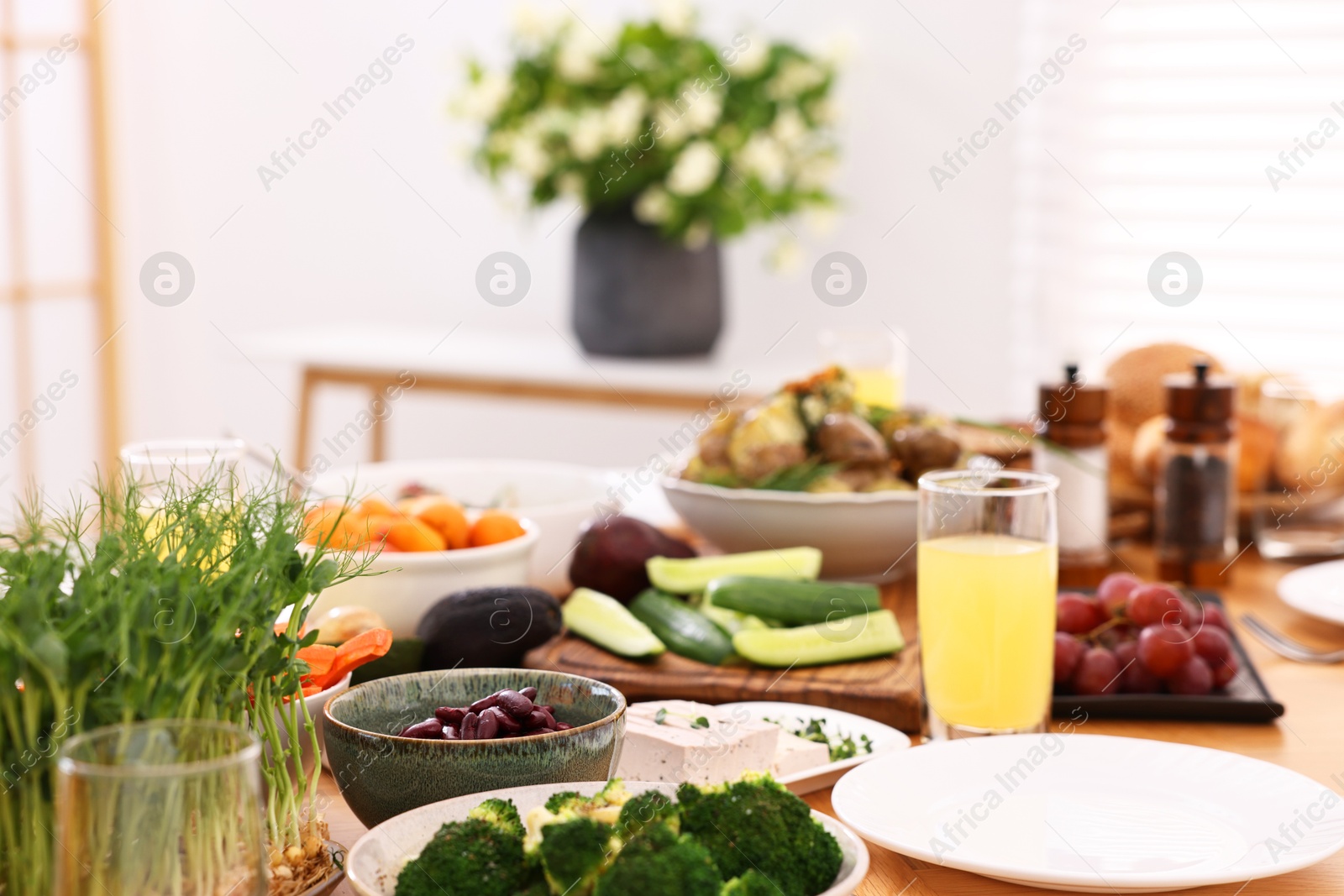 Photo of Healthy vegetarian food and glass of juice on table indoors