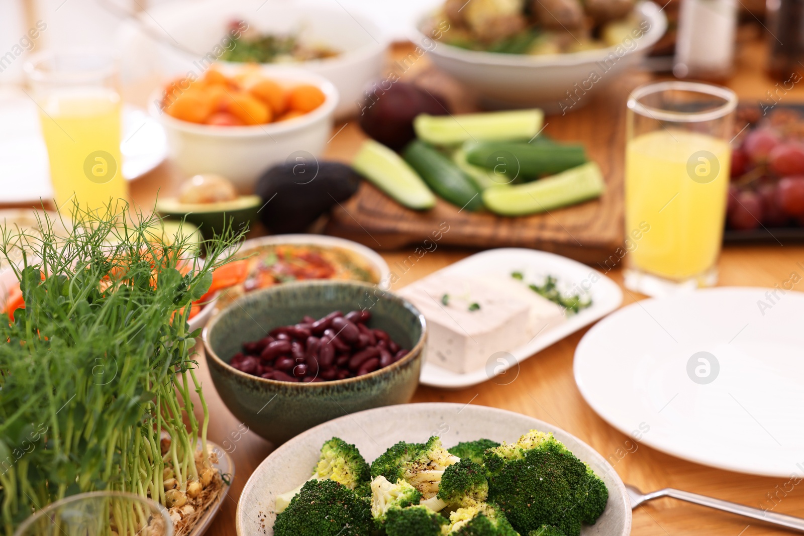 Photo of Healthy vegetarian food and glasses of juice on wooden table