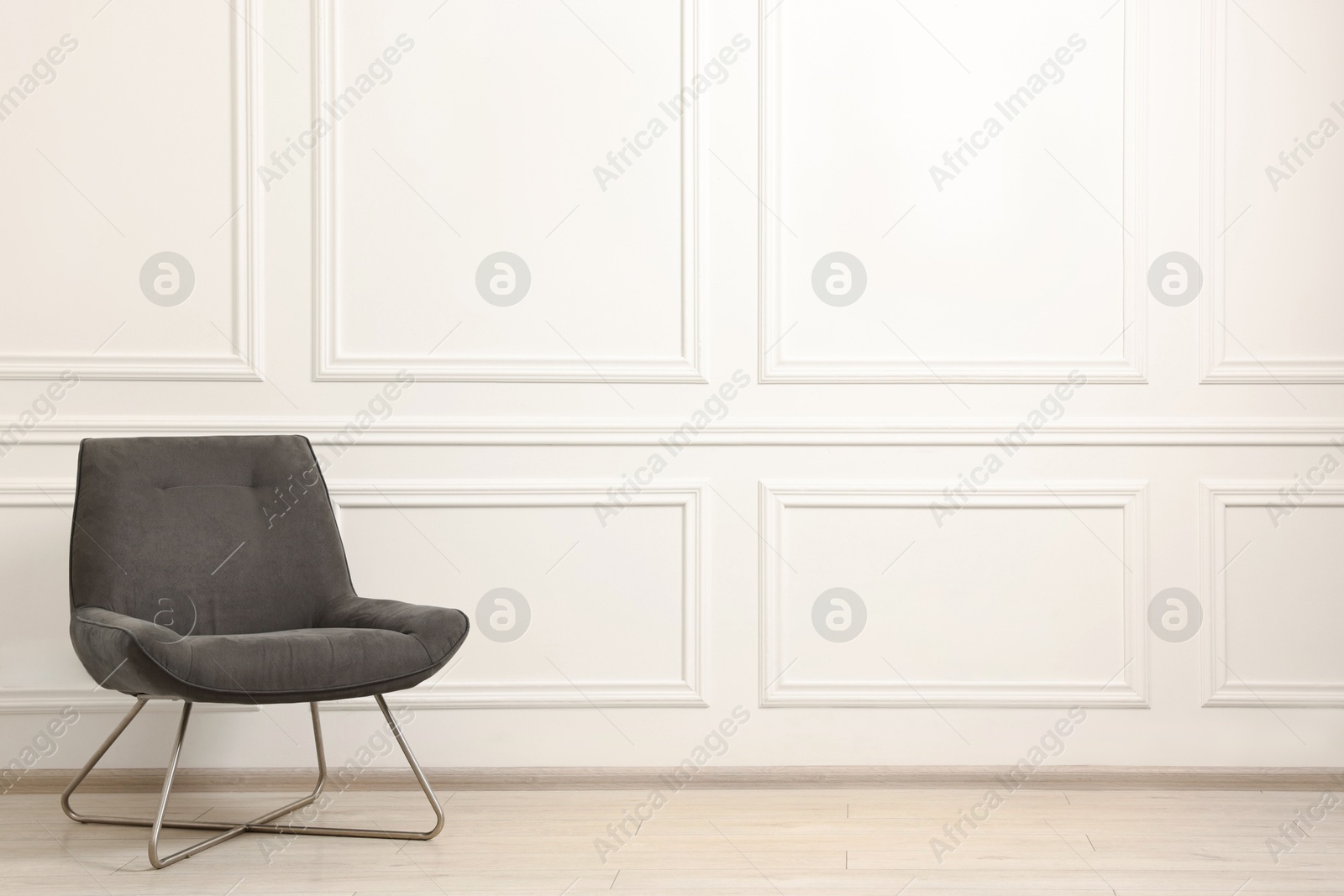 Photo of Soft armchair in light room. Space for text