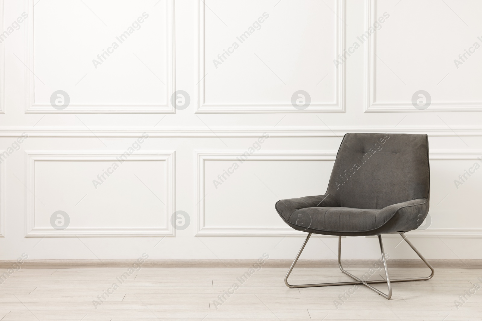 Photo of Soft armchair in light room. Space for text