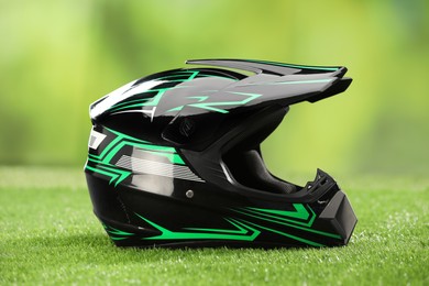 Photo of Modern motorcycle helmet with visor on green grass