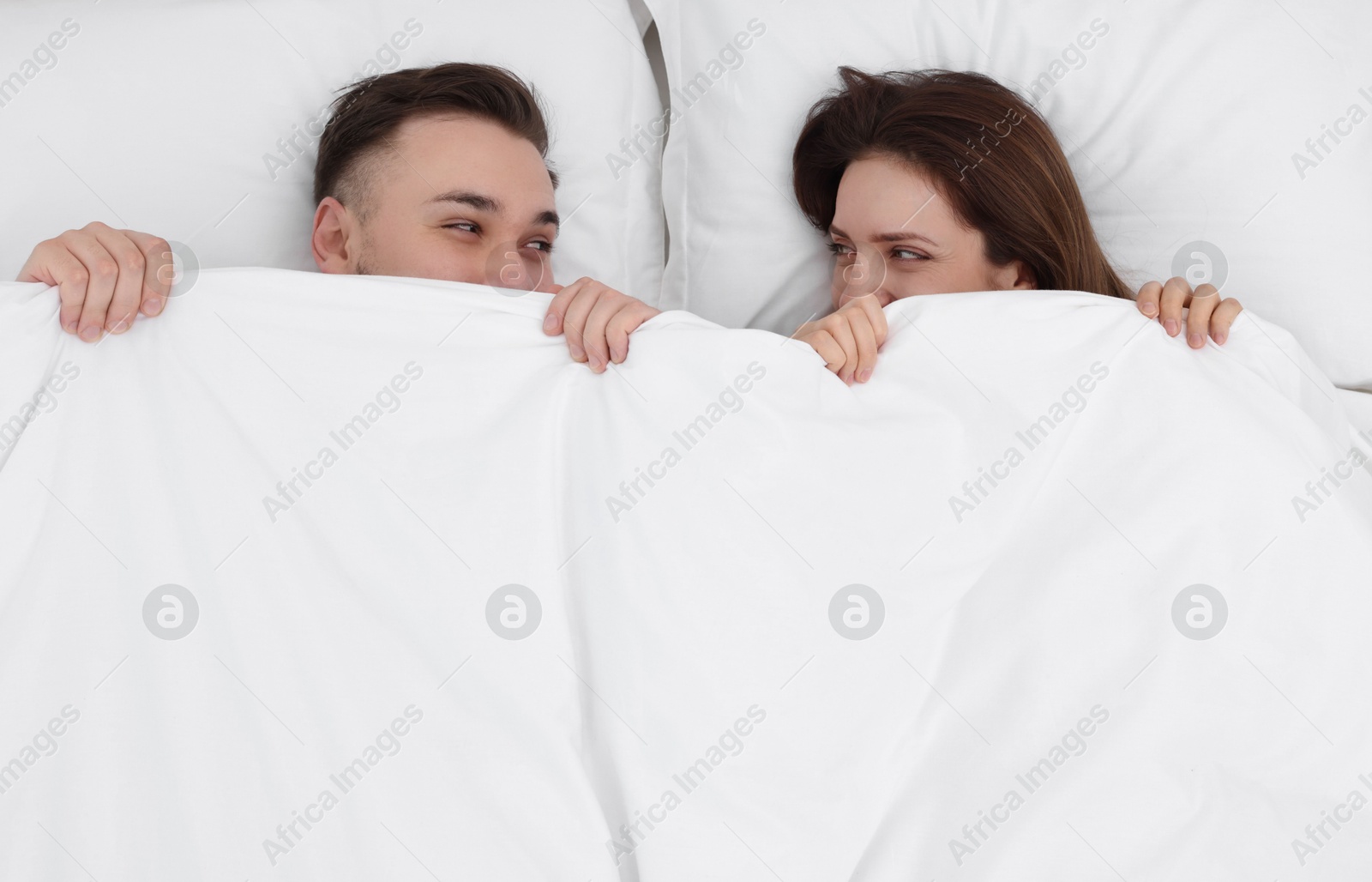 Photo of Lovely couple lying in bed at home, above view