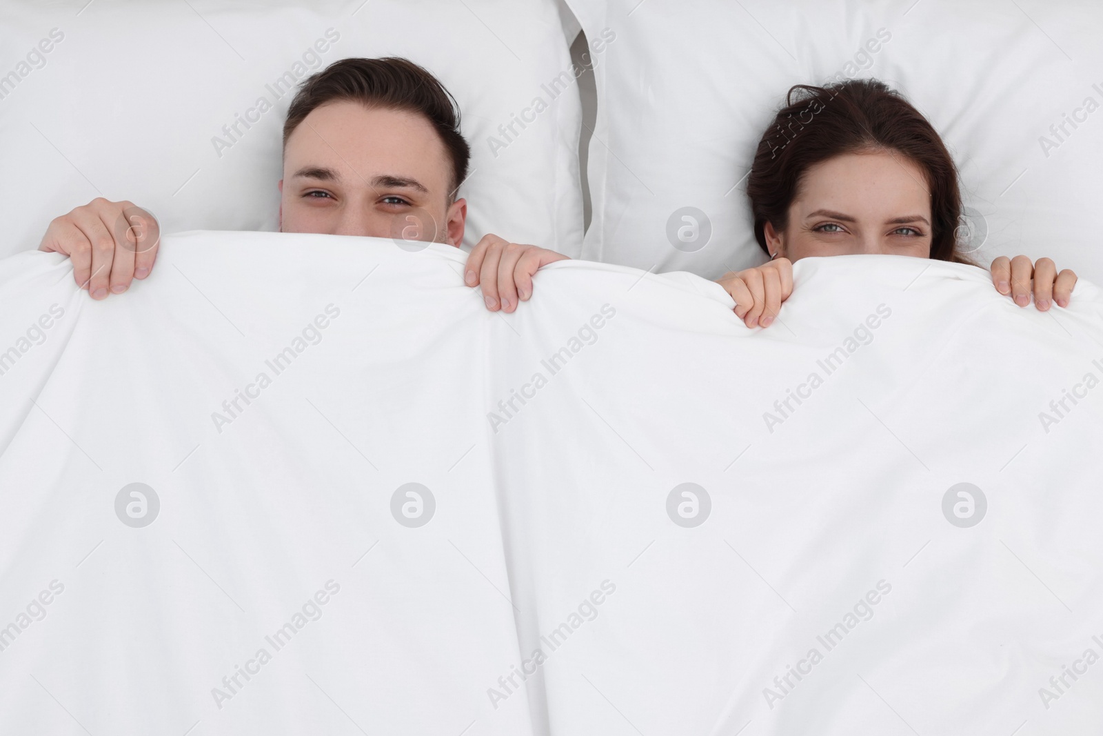 Photo of Lovely couple lying in bed at home, above view